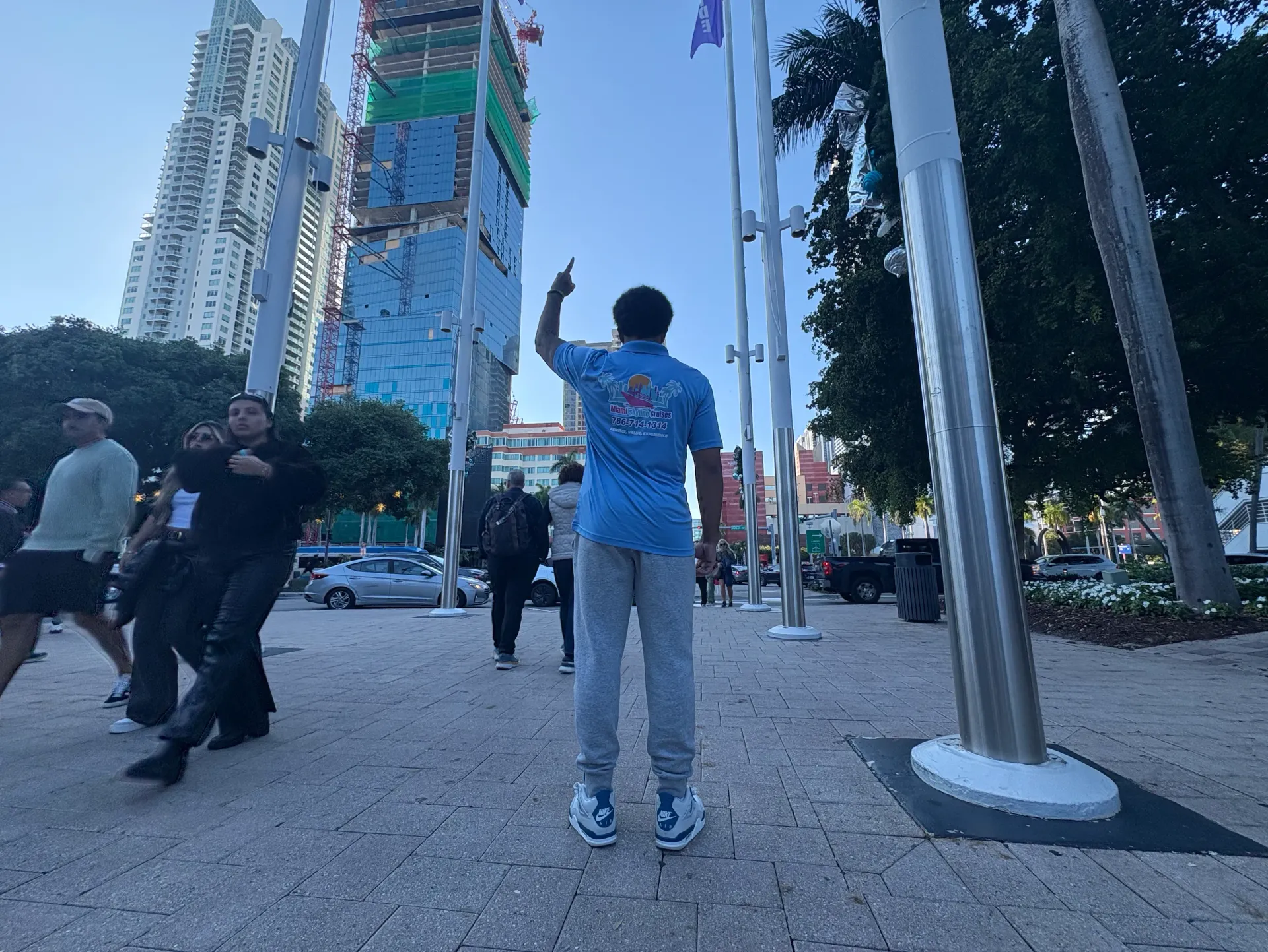 Local Miami tour guide pointing toward the Downtown Miami skyline while leading a guided sightseeing tour.