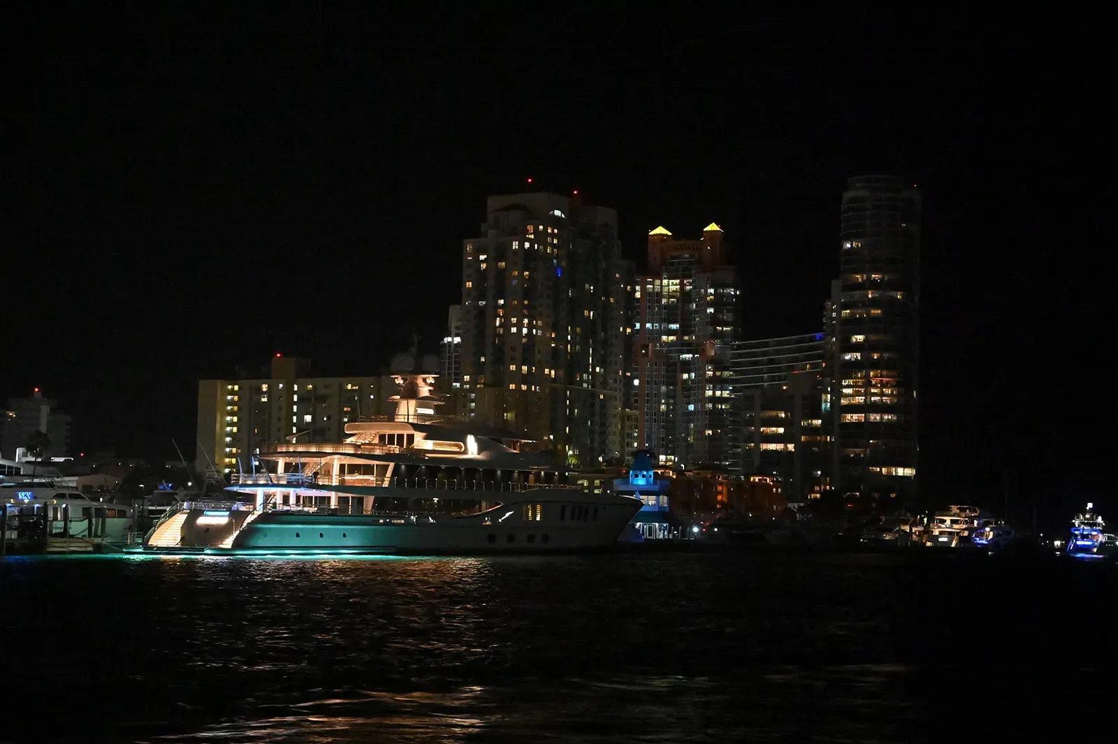 Luxury yacht and Downtown Miami skyline illuminated at night along Biscayne Bay
