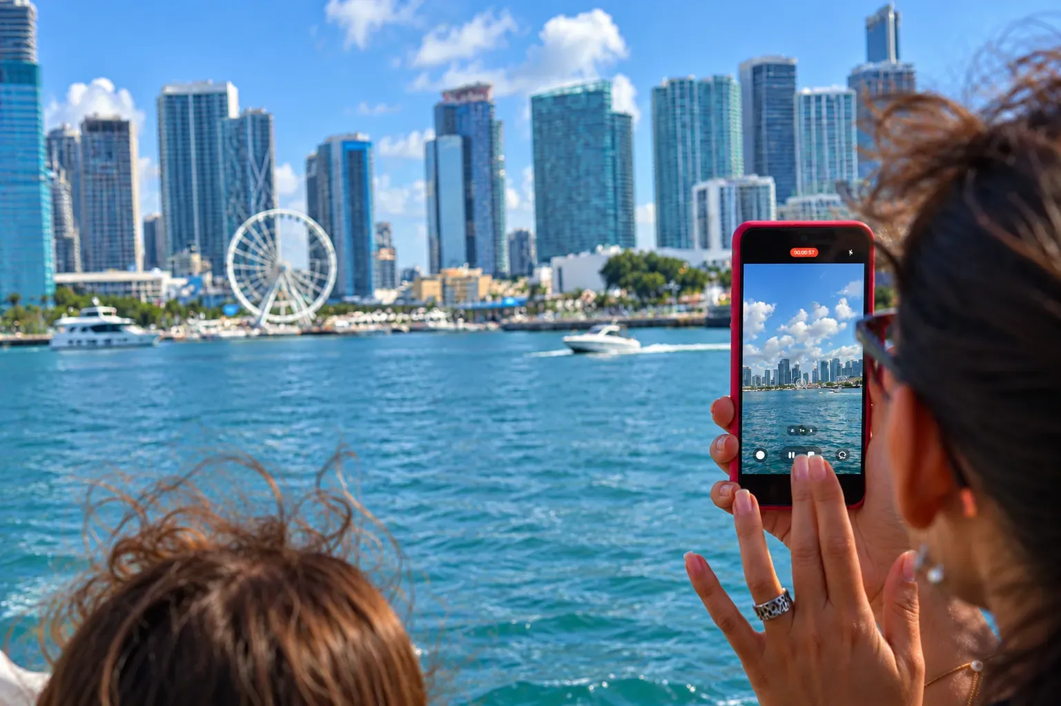 guest taking photos of the skyline of Miami on board a Miami Boat Cruise.