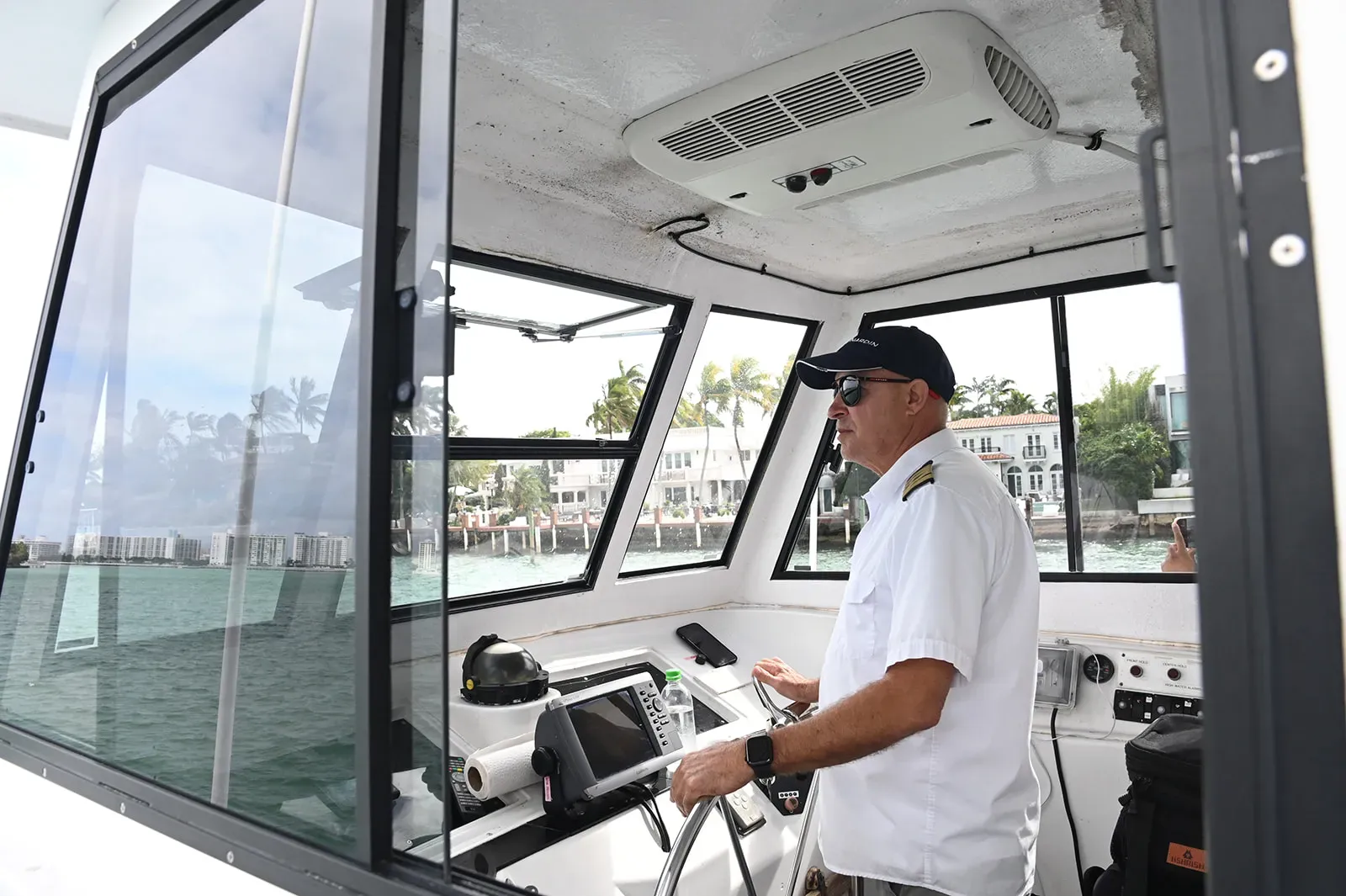 Captain operating the sightseeing boat from the wheelhouse in Miami.