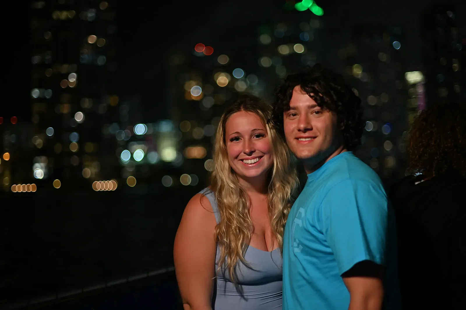 Couple enjoying a Miami Night Cruise with the illuminated Downtown Miami skyline in the background.