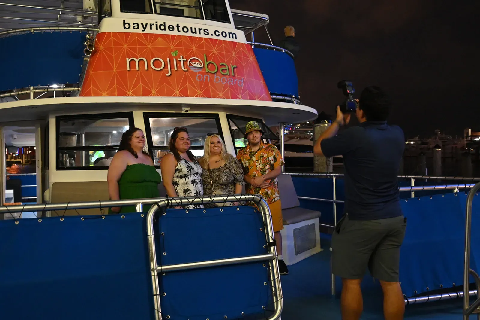 Guests taking photos and enjoying the Mojito Bar during a Miami Night Cruise on Biscayne Bay