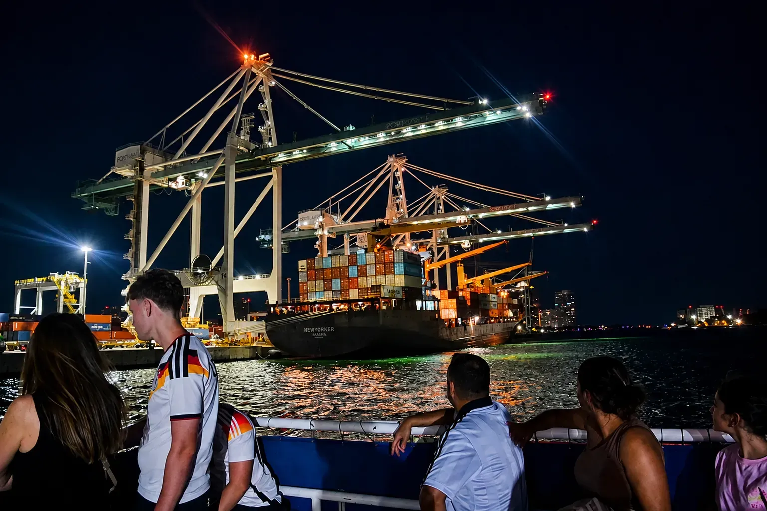 Miami Night Cruise passing PortMiami container ships and illuminated cargo cranes at night.