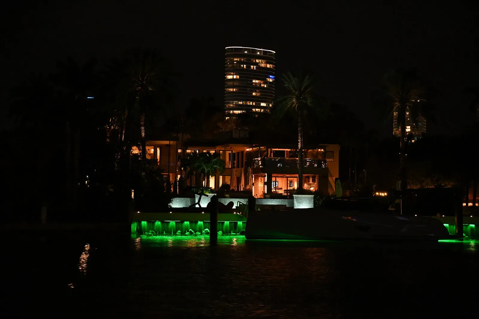Luxury waterfront home illuminated at night during one of the Miami Night Cruises on Biscayne Bay