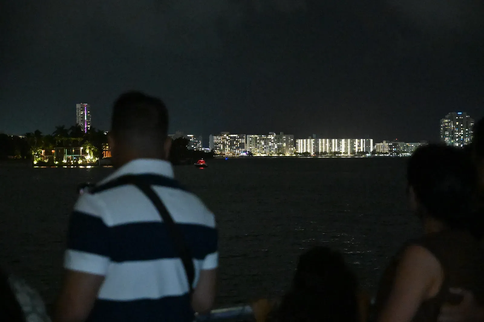 Guests enjoying nighttime views of Biscayne Bay during a Miami sightseeing boat tour