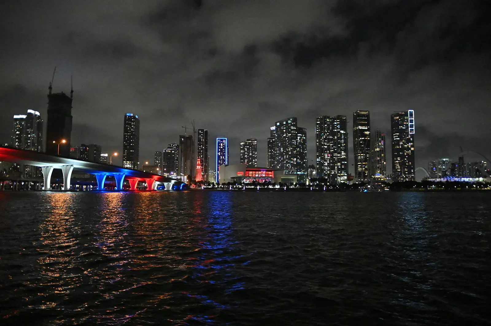 Downtown Miami skyline lights reflecting across Biscayne Bay during a nighttime sightseeing cruise