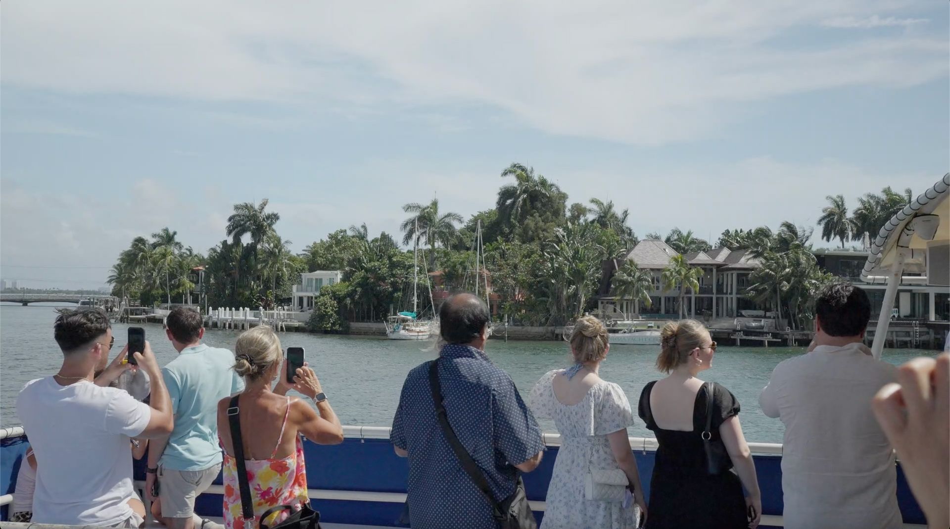 Passengers enjoying a waterfront boat tour in Miami while viewing waterfront homes along Biscayne Bay