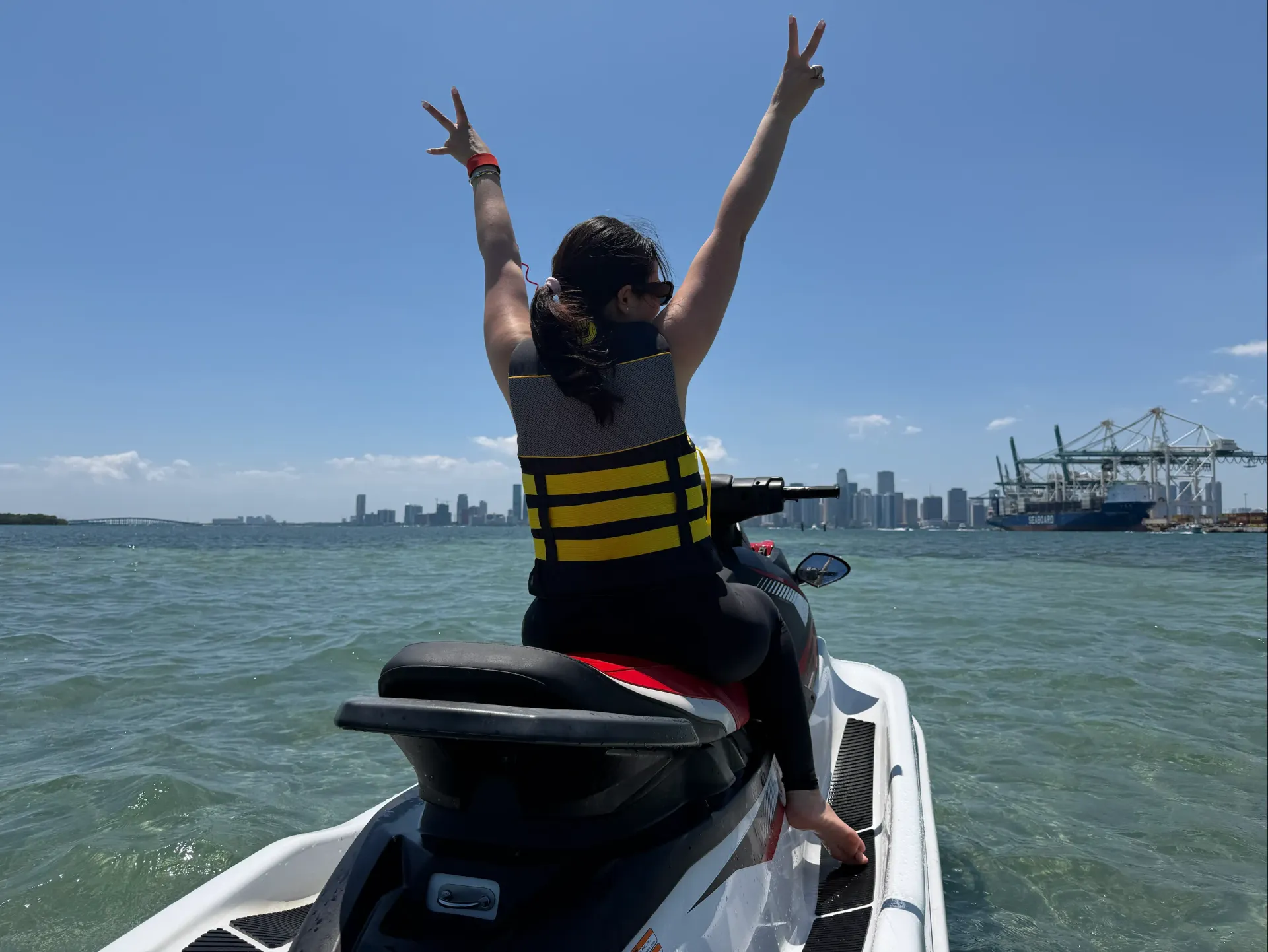 Guest riding a jet ski across Biscayne Bay with the Downtown Miami skyline during one of the most popular tours in Miami.