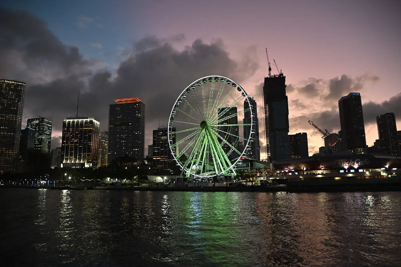 Downtown Miami skyline and Skyviews Ferris wheel during a sunset tour in Miami from the water at twilight