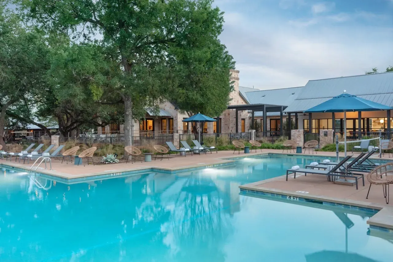 Outdoor swimming pool with lounge chairs and umbrellas.