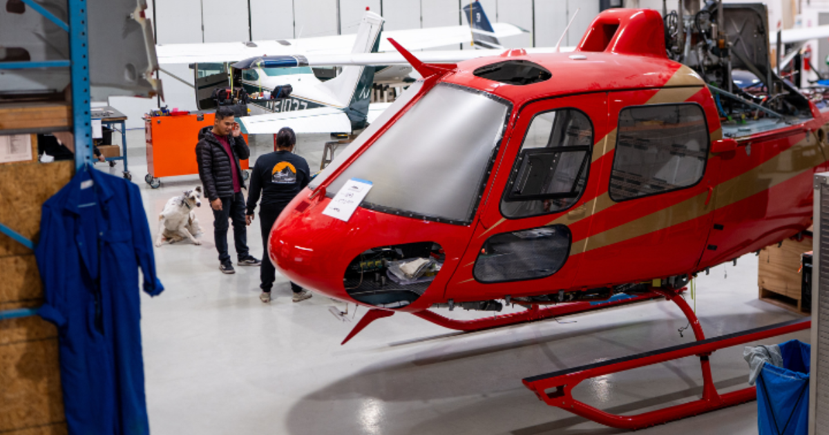 Red helicopter undergoing maintenance inside an aviation hangar in Boulder City, Nevada.