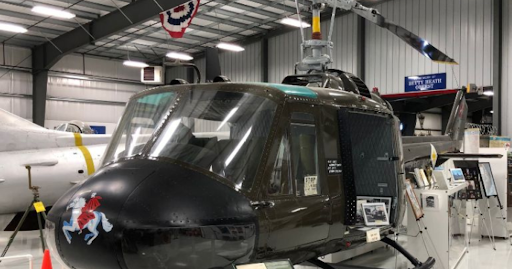Historic military helicopter on display inside an aviation hangar, illustrating the importance of FAA Part 145 certified maintenance and aircraft preservation standards.

