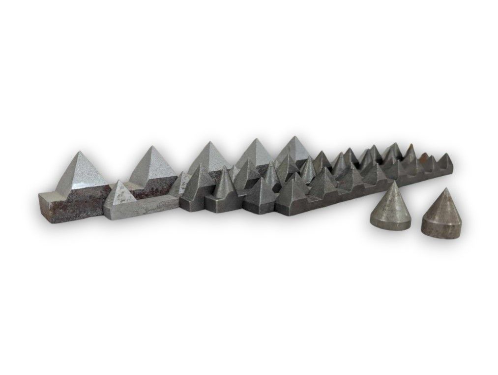 Various sizes of metal spikes and pyramids on a white surface.