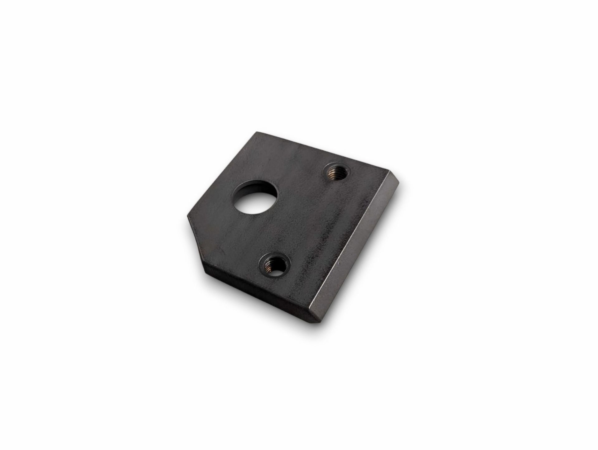 Metal plate with a round hole and two smaller holes. One corner is cut off.