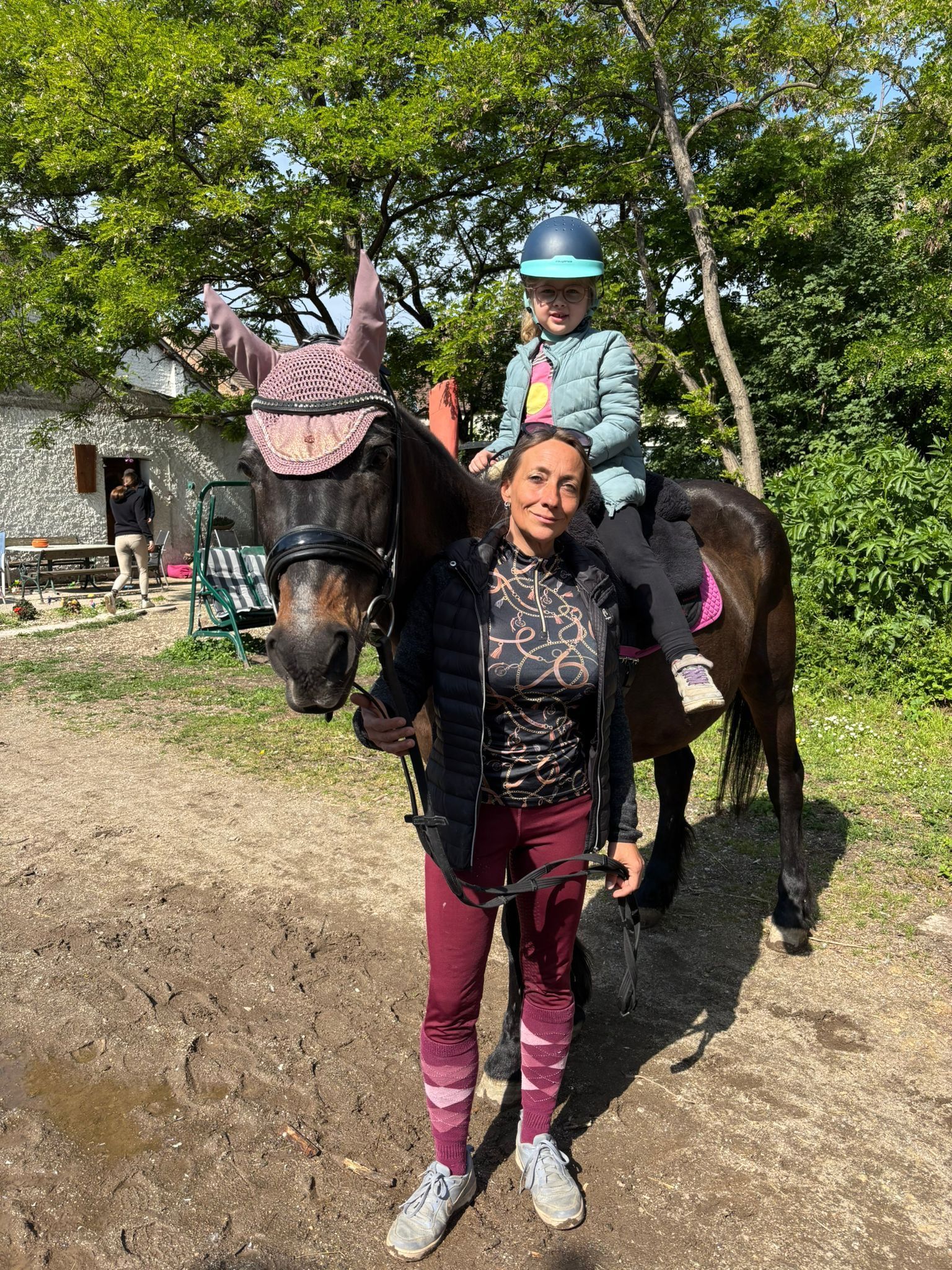 Pädagogisches Reiten mit einer Frau und einem Kind auf einem Pferd