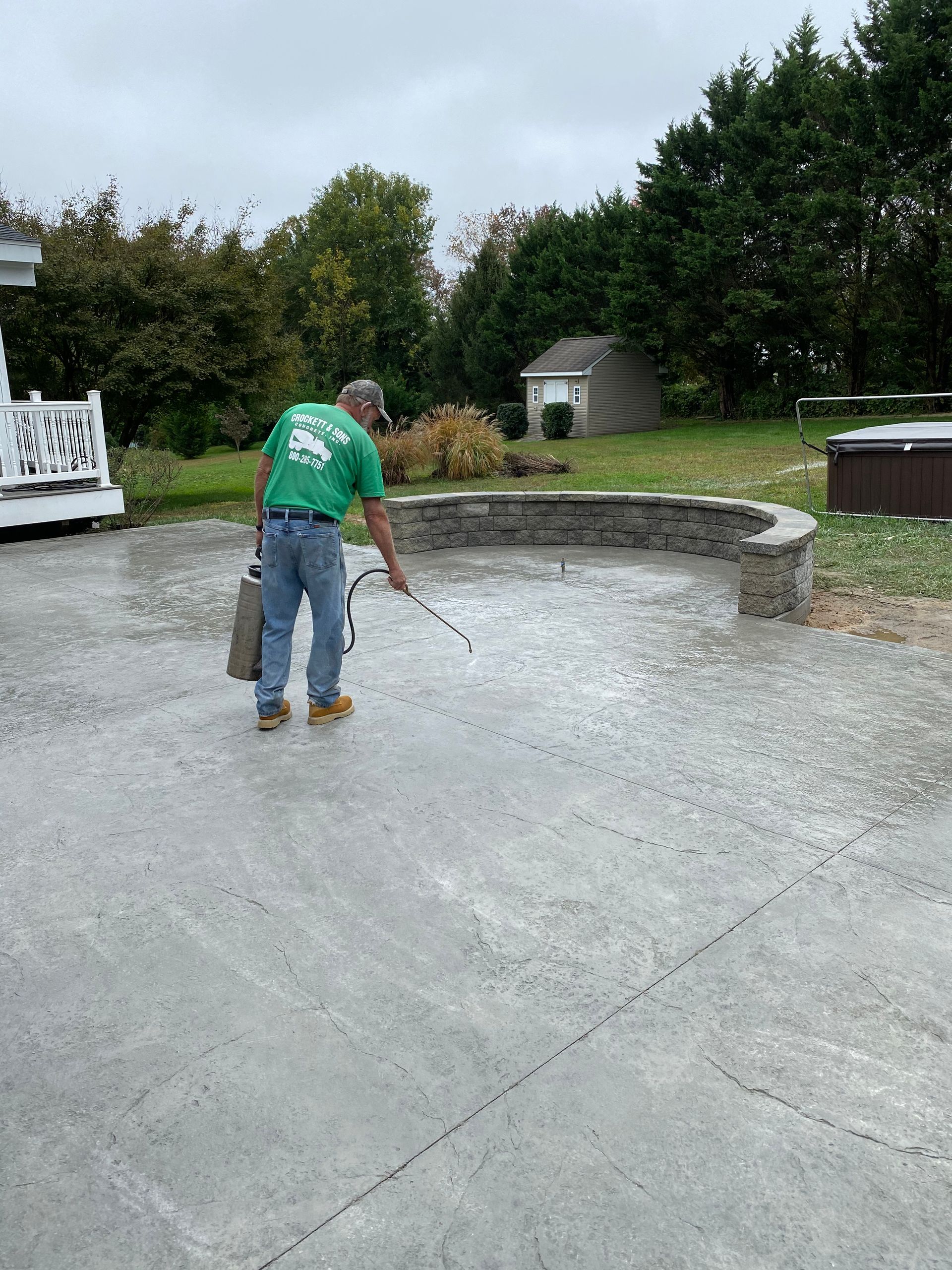 Concrete worker  spraying sealer on a new concrete patio in Oxford, Pa