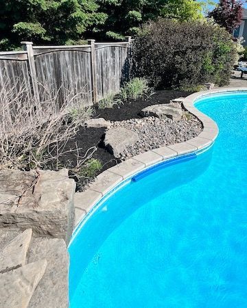 A large swimming pool with a wooden fence surrounding it.