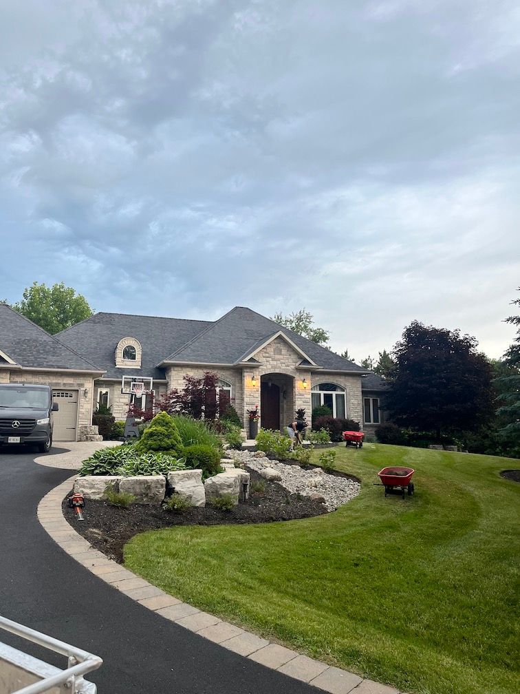 A large house with a lush green lawn and a car parked in front of it.