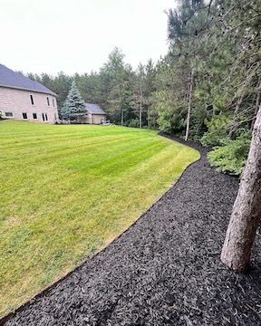 A large lawn with a house in the background and a path leading to it.