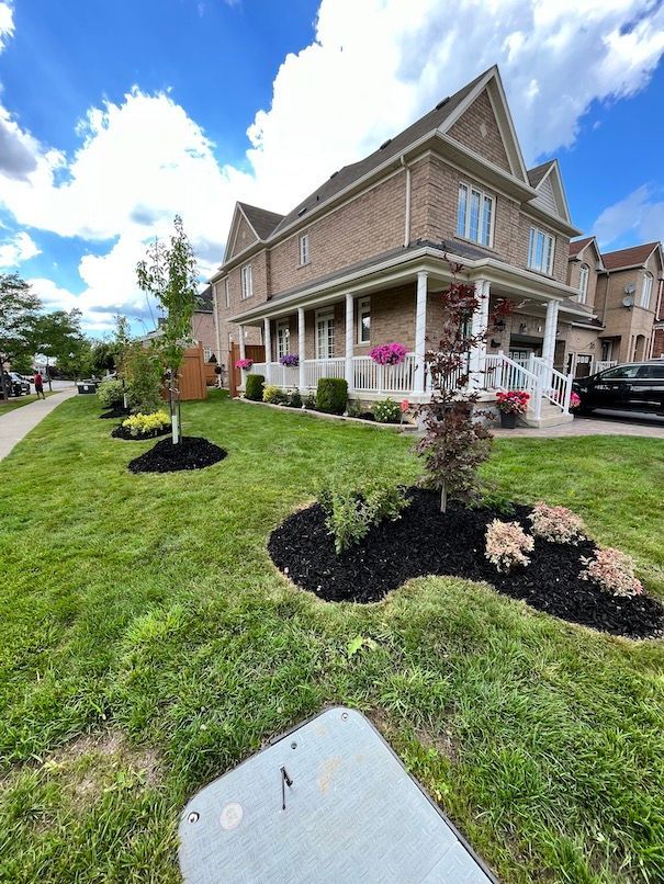A large brick house with a large lawn in front of it.