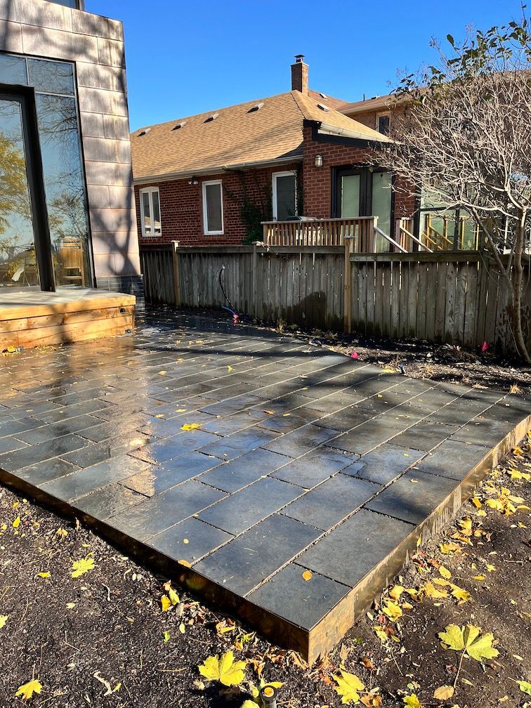 A patio with a fence and a house in the background.