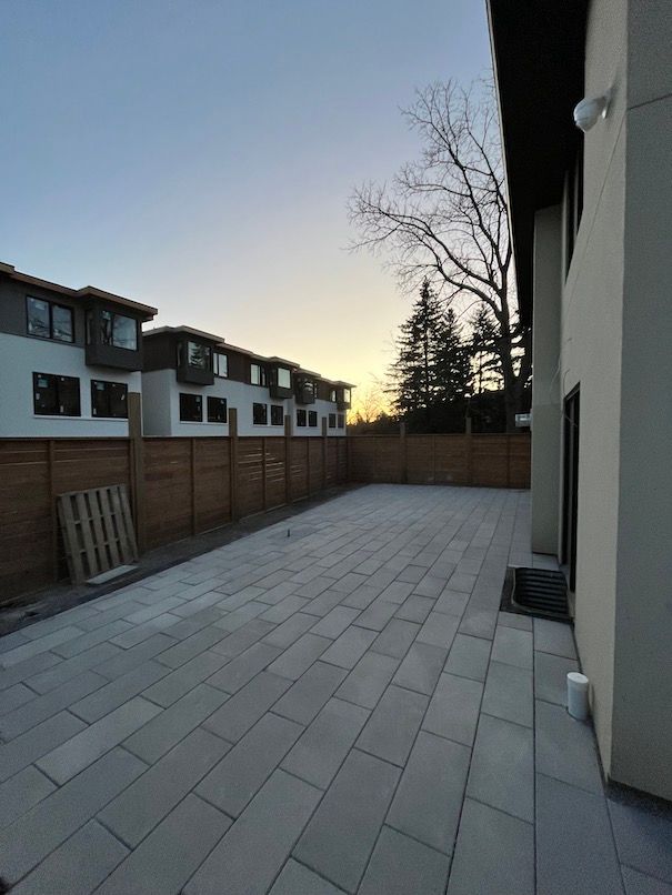 A large patio with a wooden fence in front of a house.