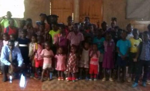 A large group of children are posing for a picture in a room.