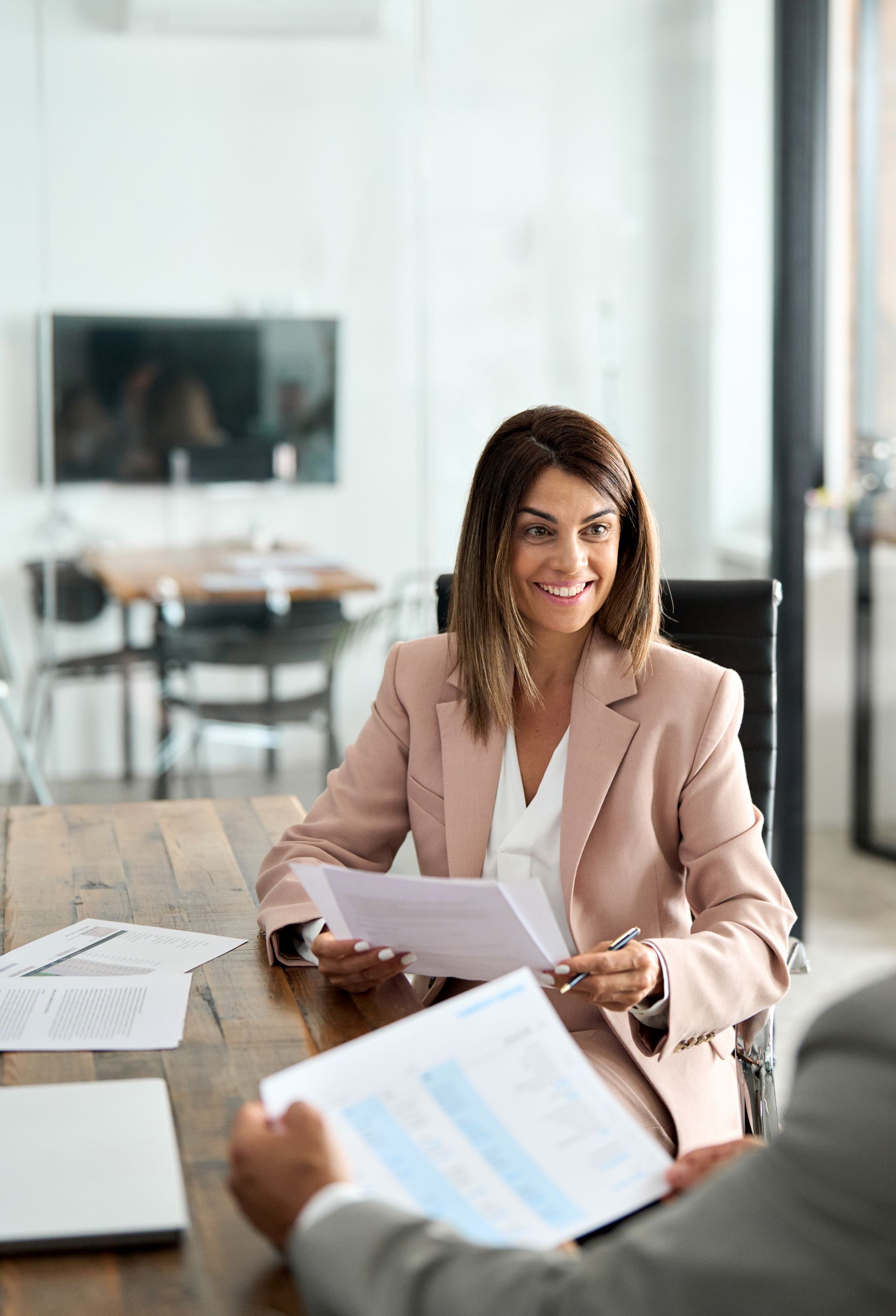 Business meeting with two people reviewing documents in a bright office Business meeting with two people reviewing documents in a bright office