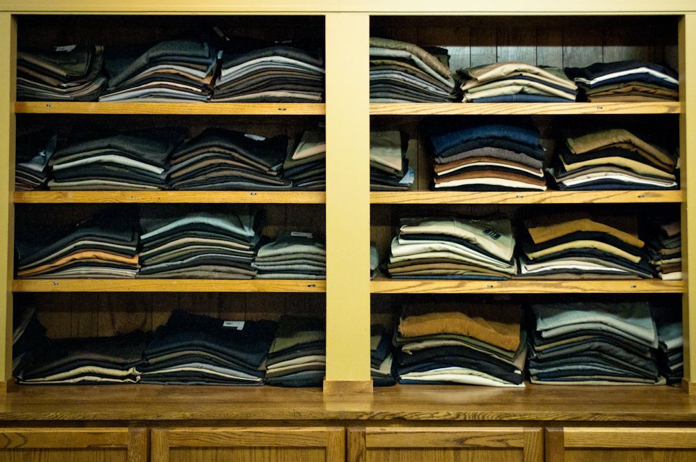 Shelves of folded men's dress pants and trousers
