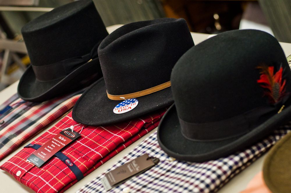 Men's black hats displayed with shirts and accessories