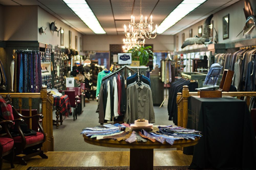 Interior of Blakley Mitchell men's clothing store with apparel displays and chandeliers
