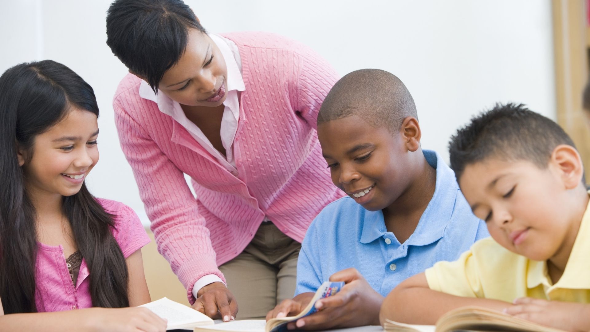 A teacher is teaching a group of children in a classroom.