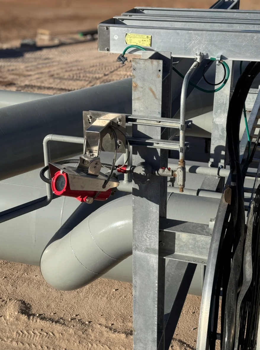 Industrial metal piping and valve assembly mounted on a frame with industrial explosion proof camera