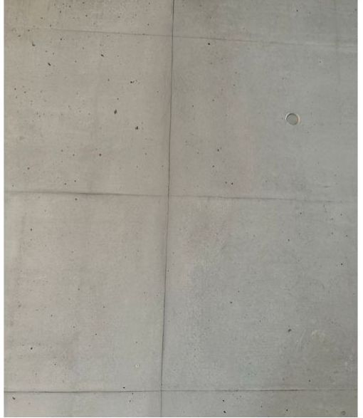 Eine Nahaufnahme einer Betonwand mit einem Loch darin.
