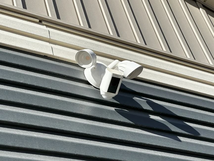 A security camera is mounted on the side of a building.