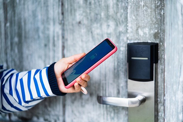 A person is using a smart phone to open a door. A person is using a smart phone to open a door.