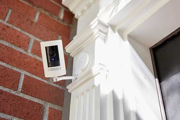A security camera is mounted on the side of a brick building. A security camera is mounted on the side of a brick building.