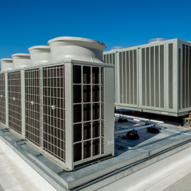 Rooftop HVAC units on a commercial building under a clear blue sky