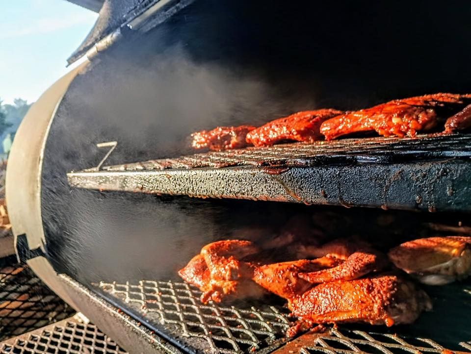 Chicken wings are being cooked in a smokehouse.