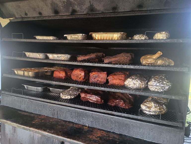 Chicken wings are being cooked in a smokehouse.