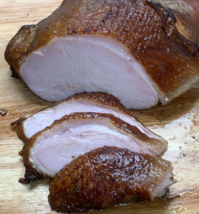 Chicken wings are being cooked in a smokehouse.