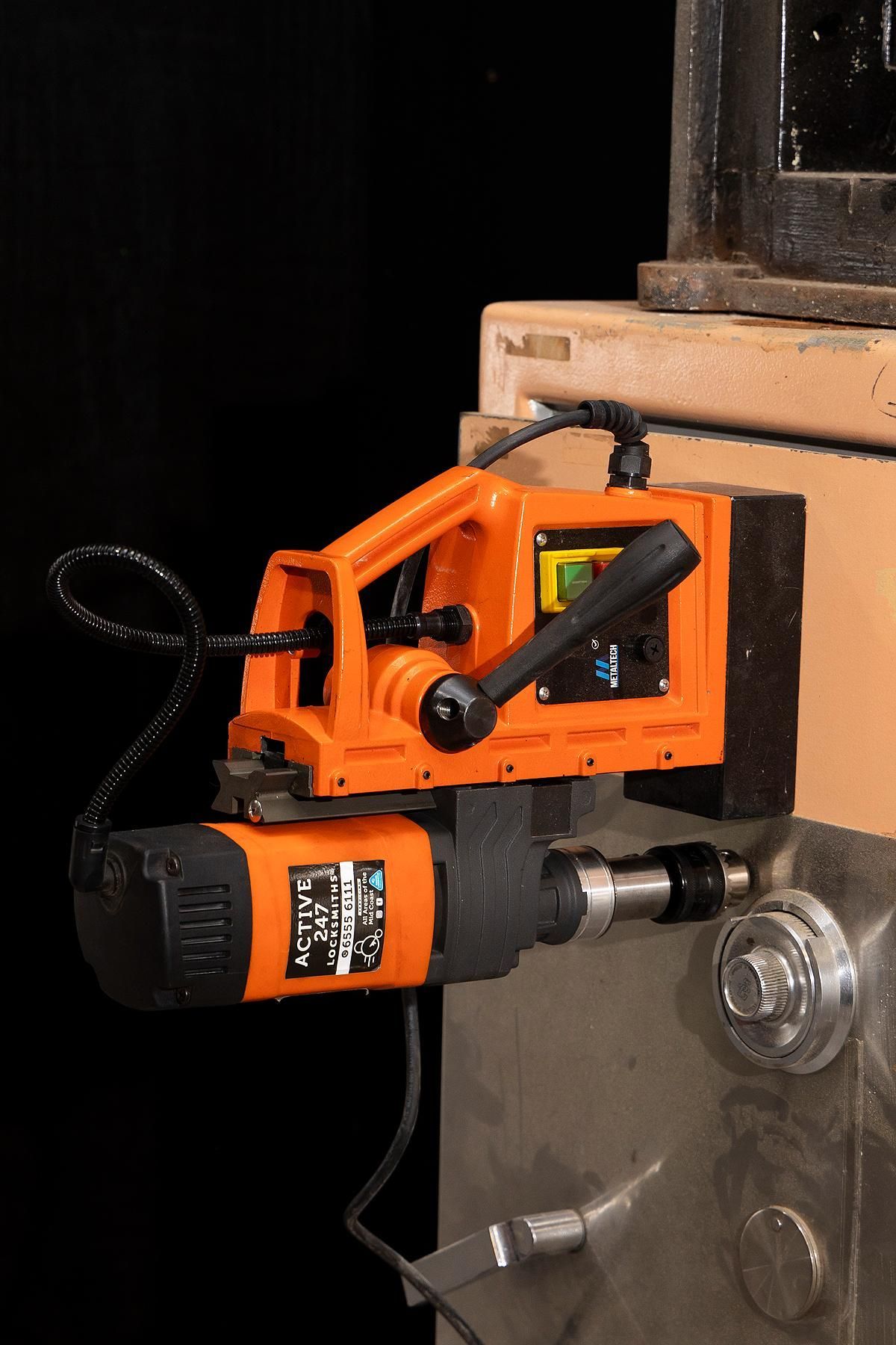 Orange Magnetic Drill Press Attached to a Metal Surface — Active 247 Locksmith and Security Services Forster in Forster, NSW