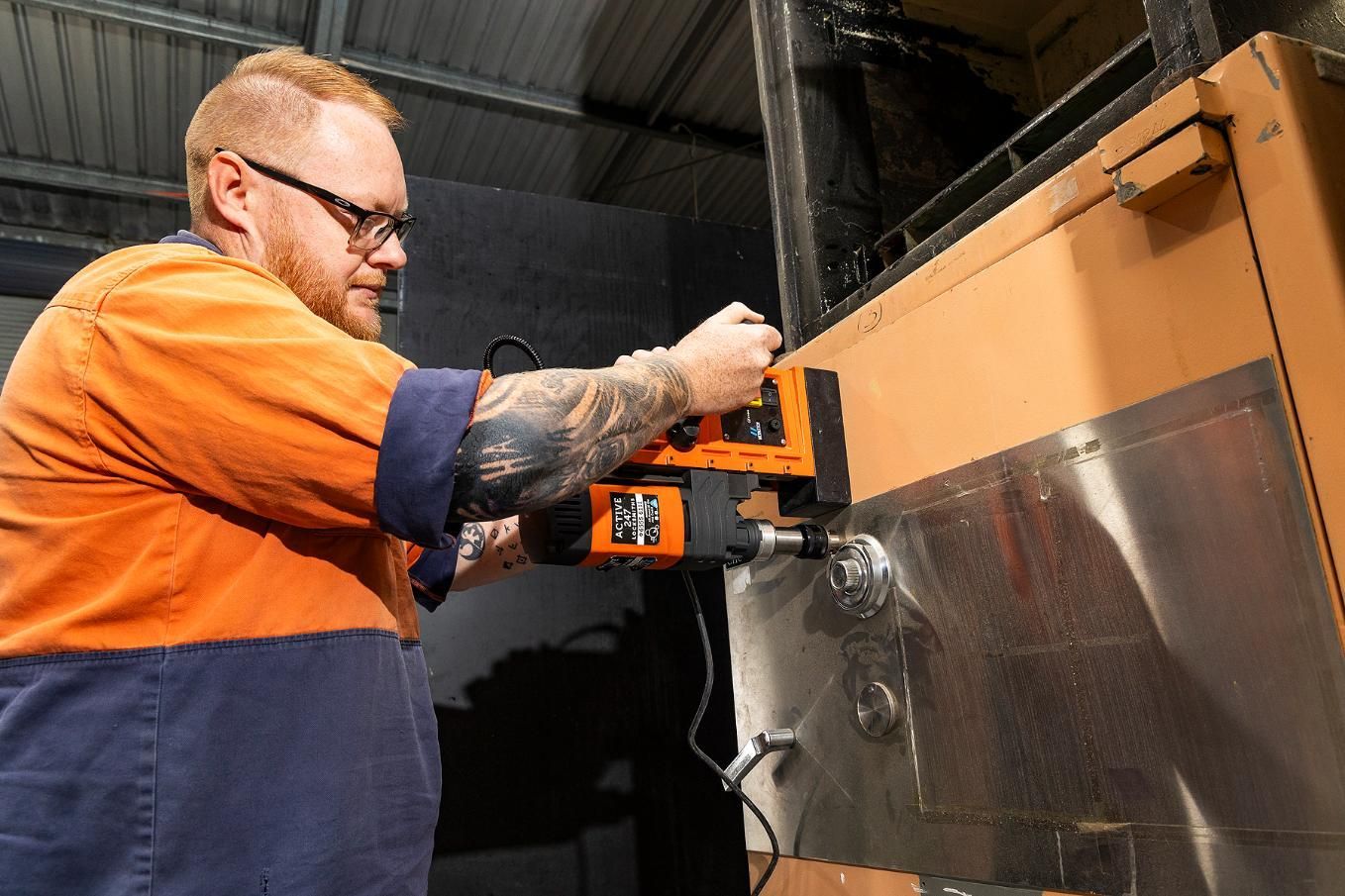 Man Using a Magnetic Drill on a Metal Surface — Active 247 Locksmith and Security Services Forster In Forster, NSW