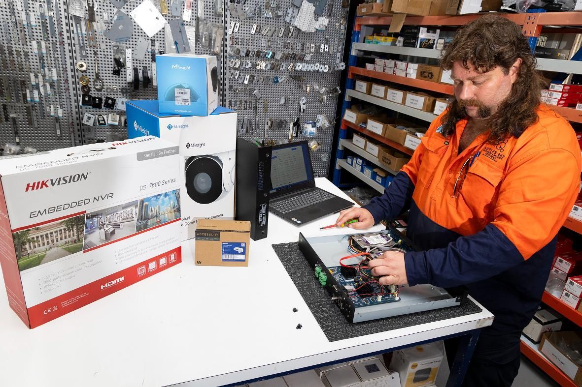 Man With Mullet Working on Electronics at a Table — Active 247 Locksmith and Security Services Forster In Forster, NSW