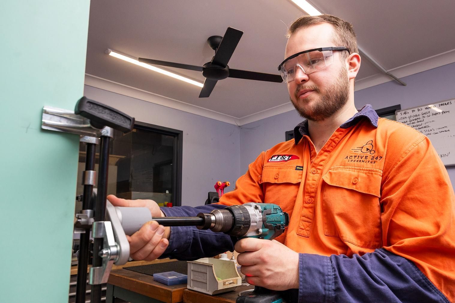 Man in Orange Work Shirt, Safety Glasses — Active 247 Locksmith and Security Services Forster In Forster, NSW