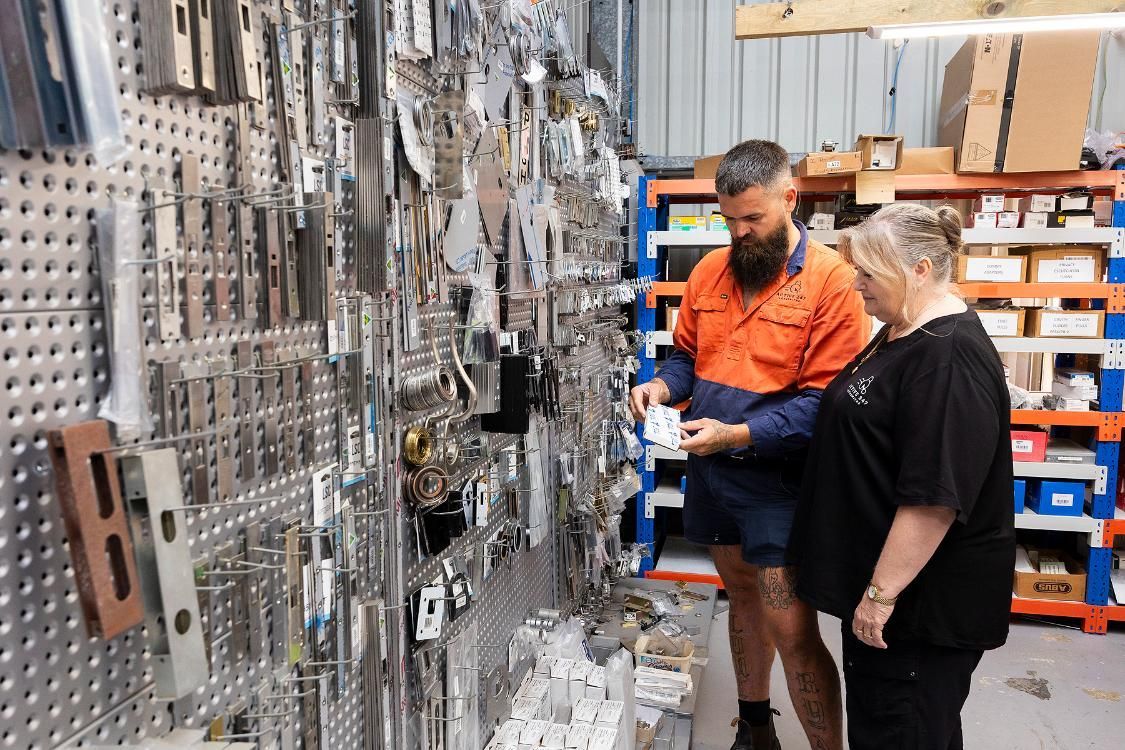 Man and Woman Looking at Keys on a Pegboard Wall — Active 247 Locksmith and Security Services Forster In Forster, NSW