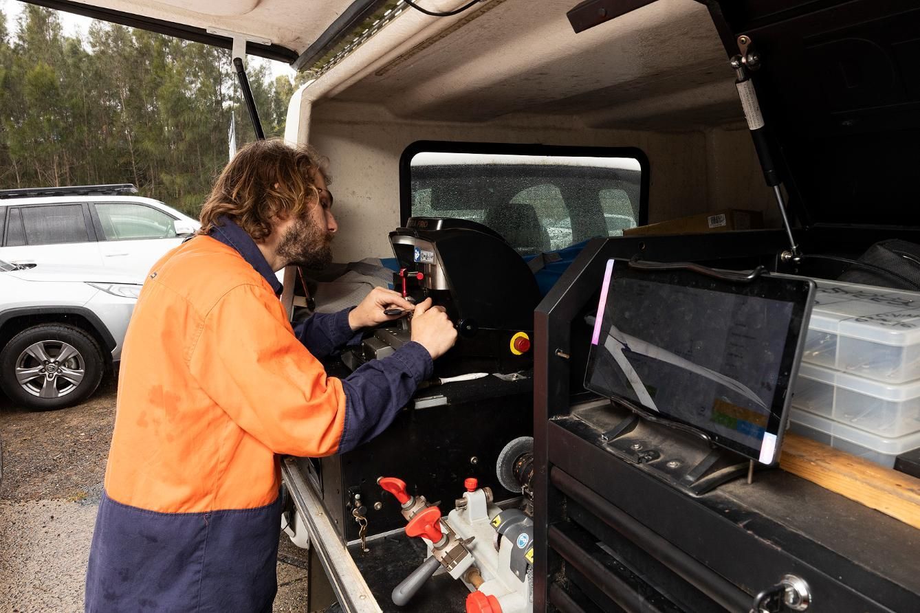 Man in Orange Jacket Working Inside a Service Vehicle — Active 247 Locksmith and Security Services Forster In Forster, NSW