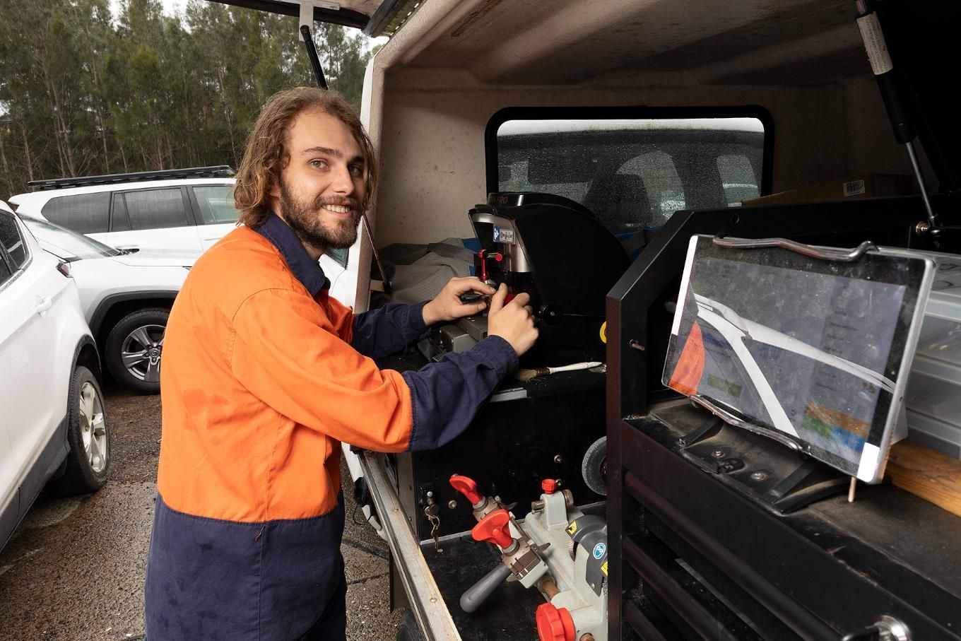 Man in Orange Work Shirt Works on Equipment — Active 247 Locksmith and Security Services Forster in Taree, NSW
