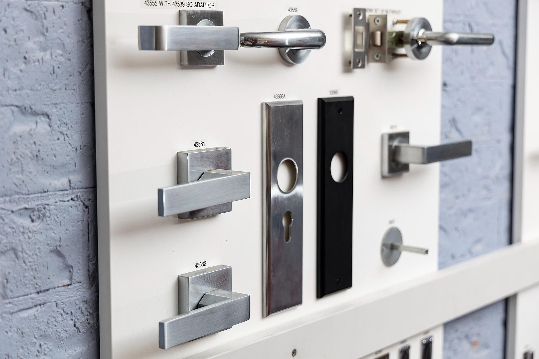 Display of Various Metal Door Handles on a White Board — Active 247 Locksmith and Security Services Forster In Old Bar, NSW
