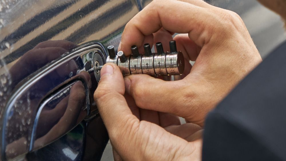 Hands Using a Lock Pick on a Car Door Handle — Active 247 Locksmith and Security Services Forster In Forster, NSW